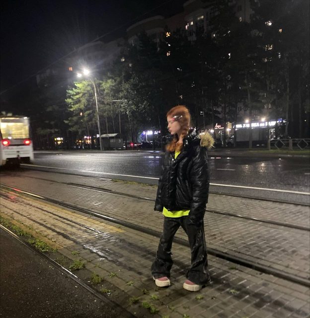 A three-image carousel of personal photos: a night street scene at a tram stop, a tilted selfie with purple hair, and a moody black-and-white portrait.