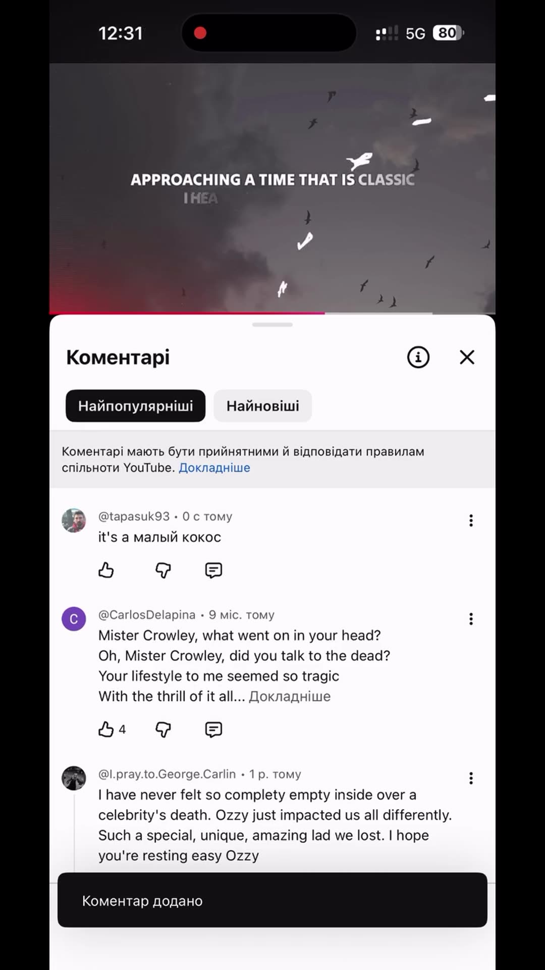 A screen recording of the YouTube app shows a lyric video for Ozzy Osbourne's "Mr. Crowley" playing above the comments section. A short comment is typed in English and Russian-layout keyboard and posted, then the video keeps playing.