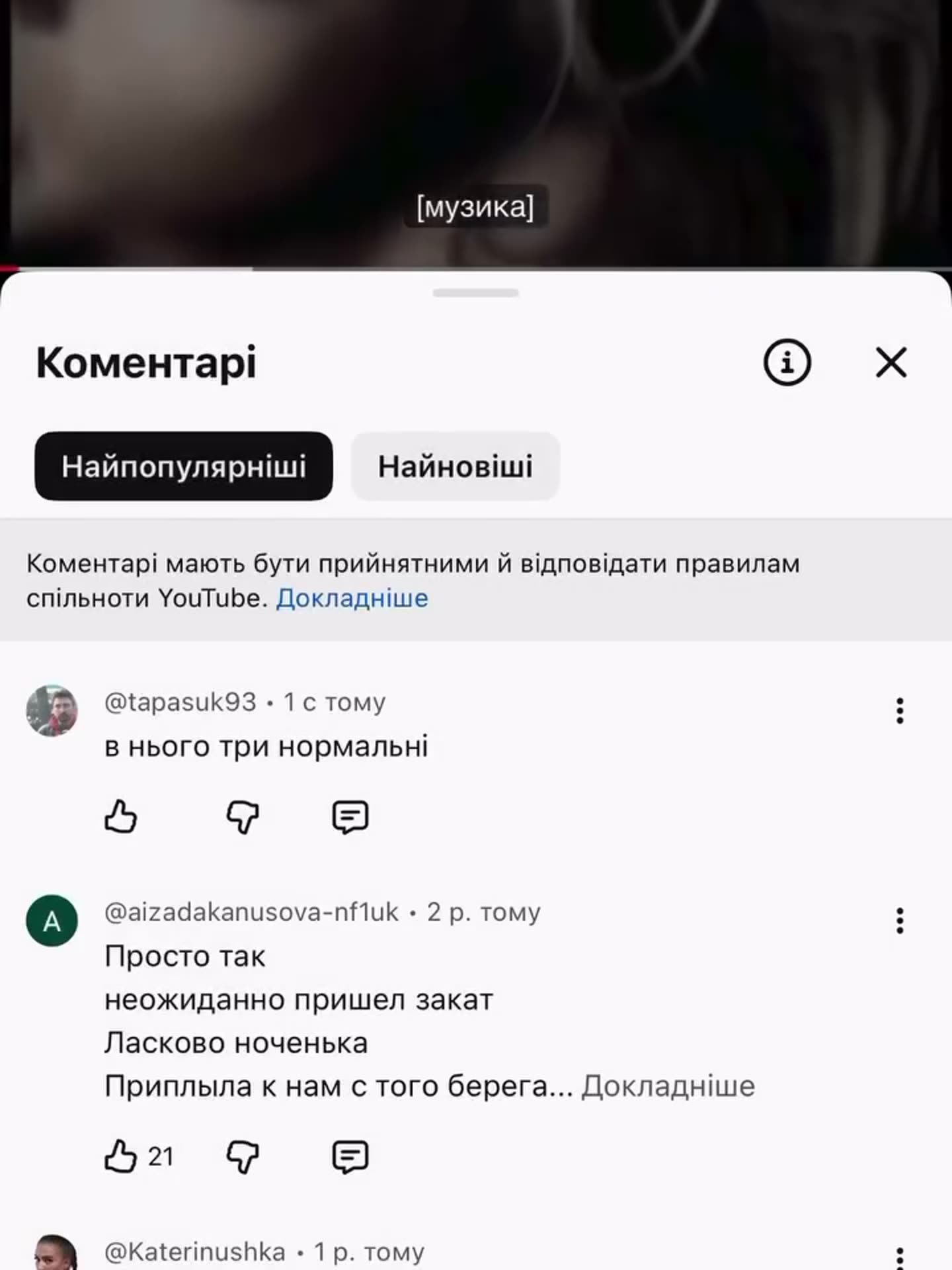 Two screen recordings of the YouTube app on a phone. The owner types a comment under music videos in Ukrainian: 'в нього три нормальні' in the first and 'у Yo, діво парубка' in the second. The comment then posts. Other users' comments are visible, and the videos above show a blurred close-up of a w…