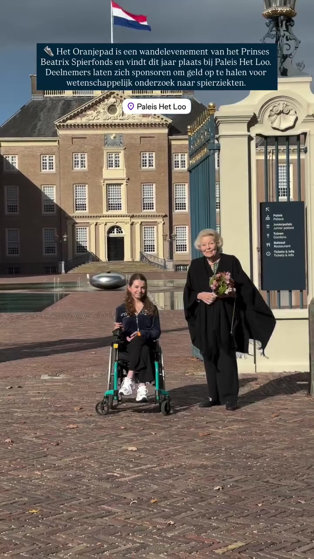 A story reshares a Koninklijk Huis video about the Oranjepad charity walk at Paleis Het Loo, showing a woman in a wheelchair meeting an elderly woman with flowers, then the orange heart decorations and walkers on the route.