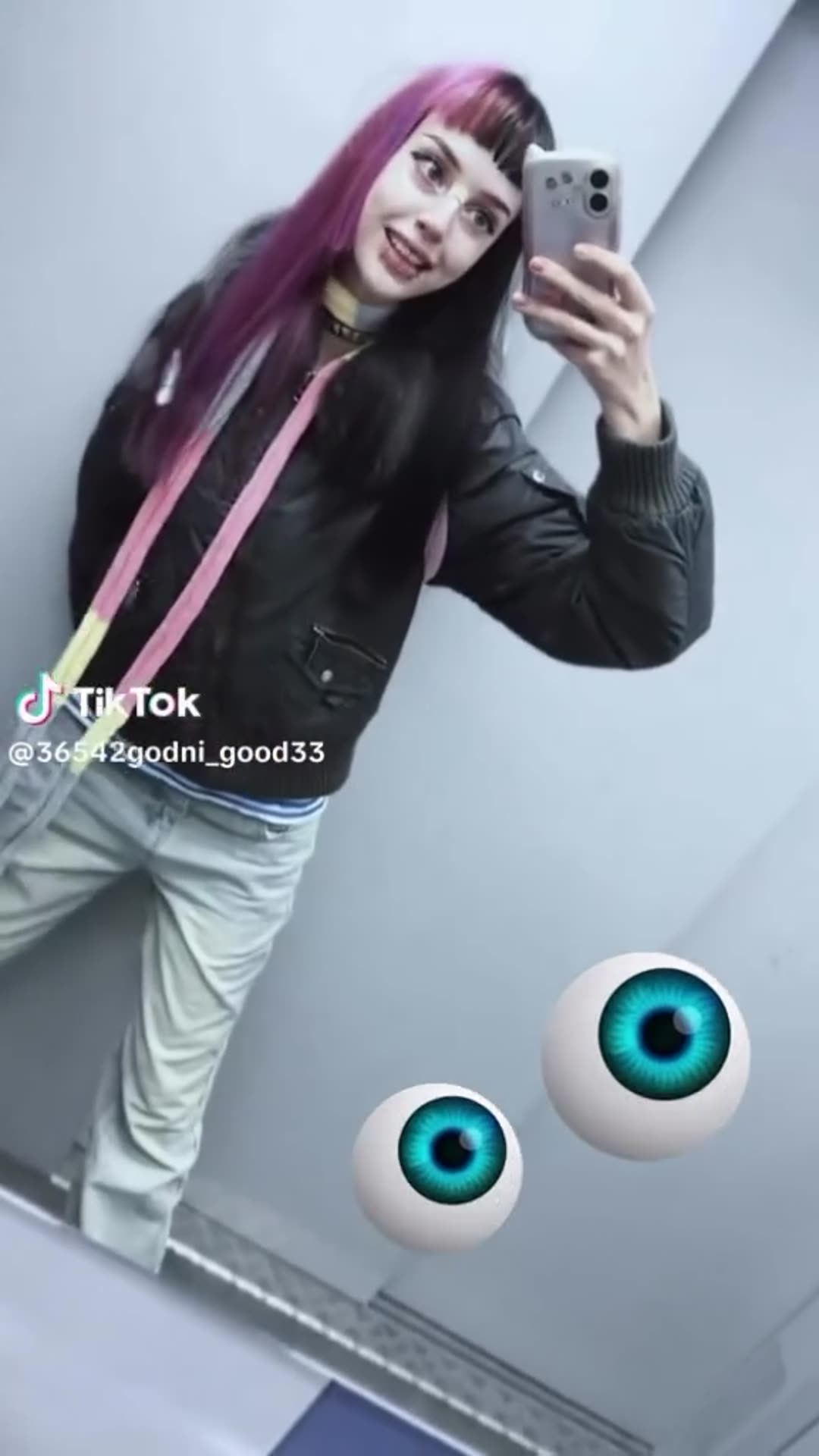 A reposted TikTok clip of a woman taking a mirror selfie in what looks like an elevator, with two cartoon eyeball stickers and a Russian voiceover reciting a possessive line about taking someone's eyes.