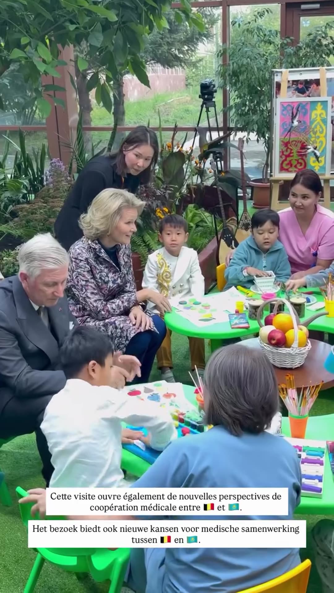 A reshared Belgian Royal Palace video of the King and Queen of the Belgians visiting a children's hospital in Astana, Kazakhstan. They join children at a craft table, greet medical staff and pose for a group photo. Overlaid French and Dutch text says the visit also opens new perspectives for medica…
