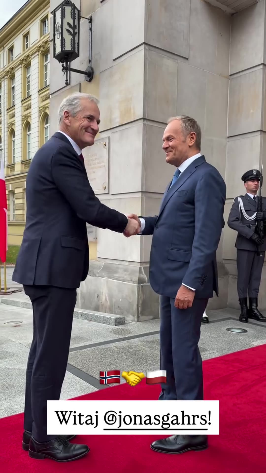A reshared story from Donald Tusk's account shows him welcoming @jonasgahrs with a handshake on a red carpet in front of an honour guard. The caption overlay reads 'Witaj @jonasgahrs!' with Norwegian and Polish flag emojis and a handshake emoji.