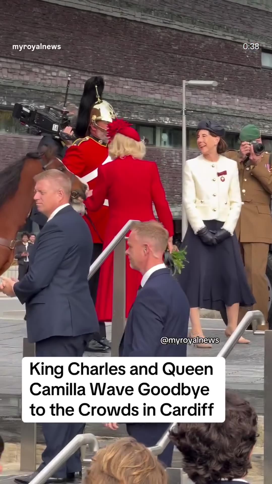A reshared reel from @myroyalnews shows King Charles III and Queen Camilla leaving the Senedd in Cardiff by car after the ceremonial opening of the Welsh Parliament, with a mounted guardsman's horse and onlookers nearby.