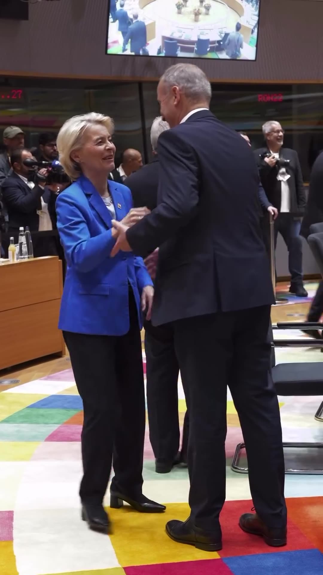 A story reshares a behind-the-scenes video by Ursula von der Leyen of her greeting leaders with hugs and handshakes in a circular summit hall, with photographers working nearby.