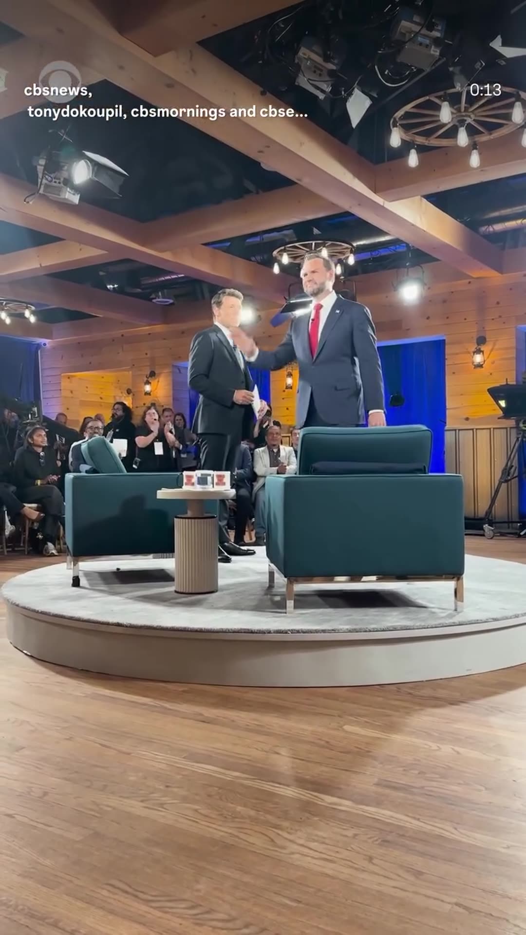 A promo clip from CBS News for its town hall with Vice President JD Vance, shot from the audience. Vance greets seated voters, then meets the host on a round stage with two teal armchairs. A title card reads that the show airs tonight at 8 p.m. ET/PT on CBS.