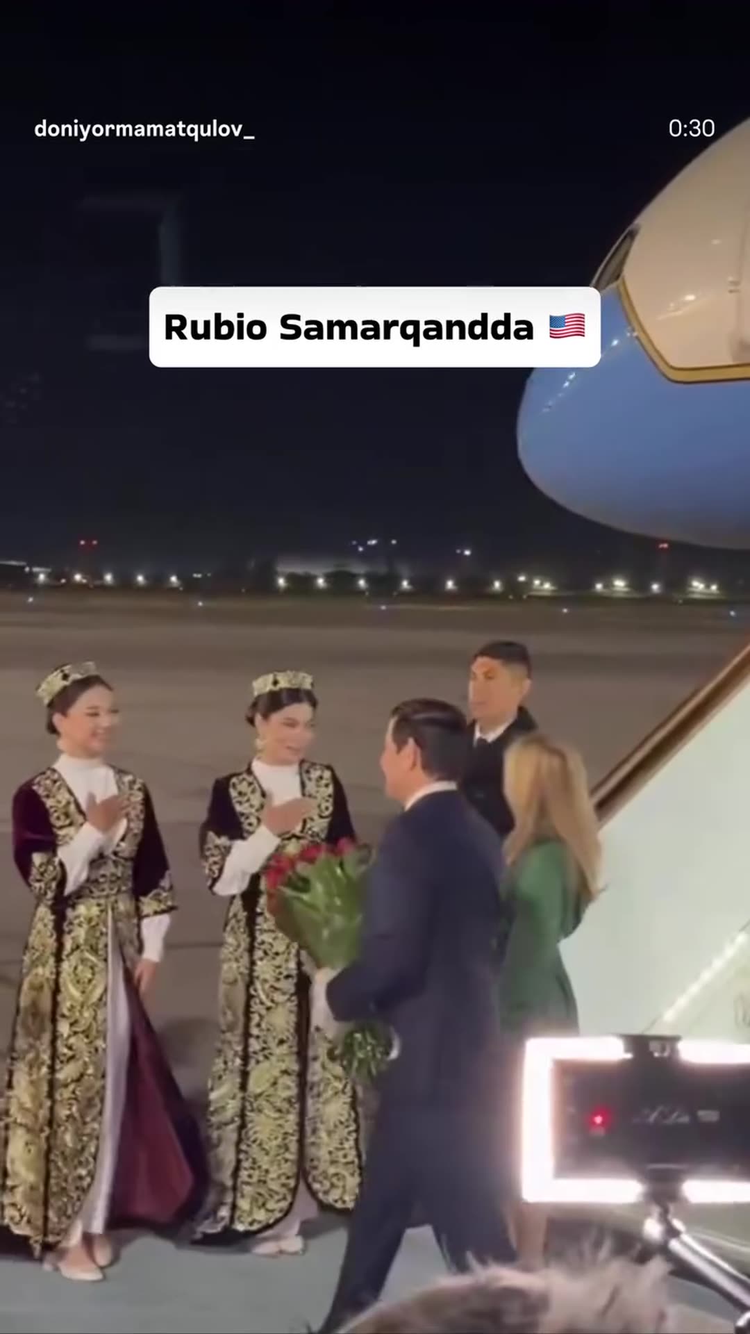 A story reshares a reel of US Secretary of State Marco Rubio arriving by night at Samarkand airport. Women in traditional costume present flowers and Uzbek officials greet him with hugs.