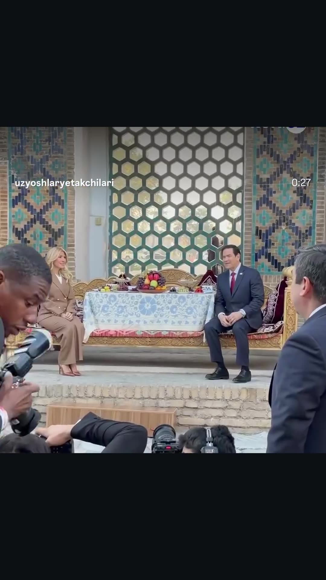 A story reshares a reel by @uzyoshlaryetakchilari showing the visiting US Secretary of State and his wife being photographed on a traditional Uzbek suri (dais) in Samarkand, then touring a tiled hall and posing with an Uzbek hostess.