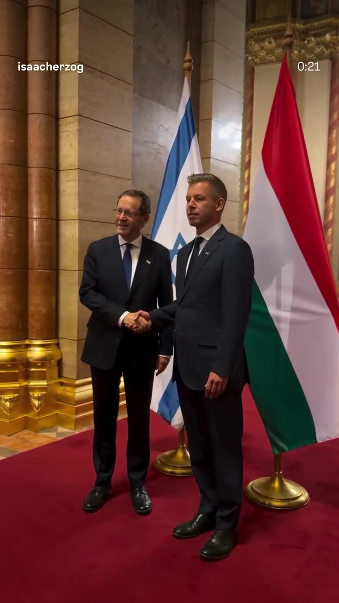A story reshares Isaac Herzog's video from the Hungarian Parliament in Budapest. He and Hungary's Prime Minister exchange thanks, pose for a handshake in front of the Israeli and Hungarian flags, and walk through the building. The Prime Minister is invited to visit Israel.