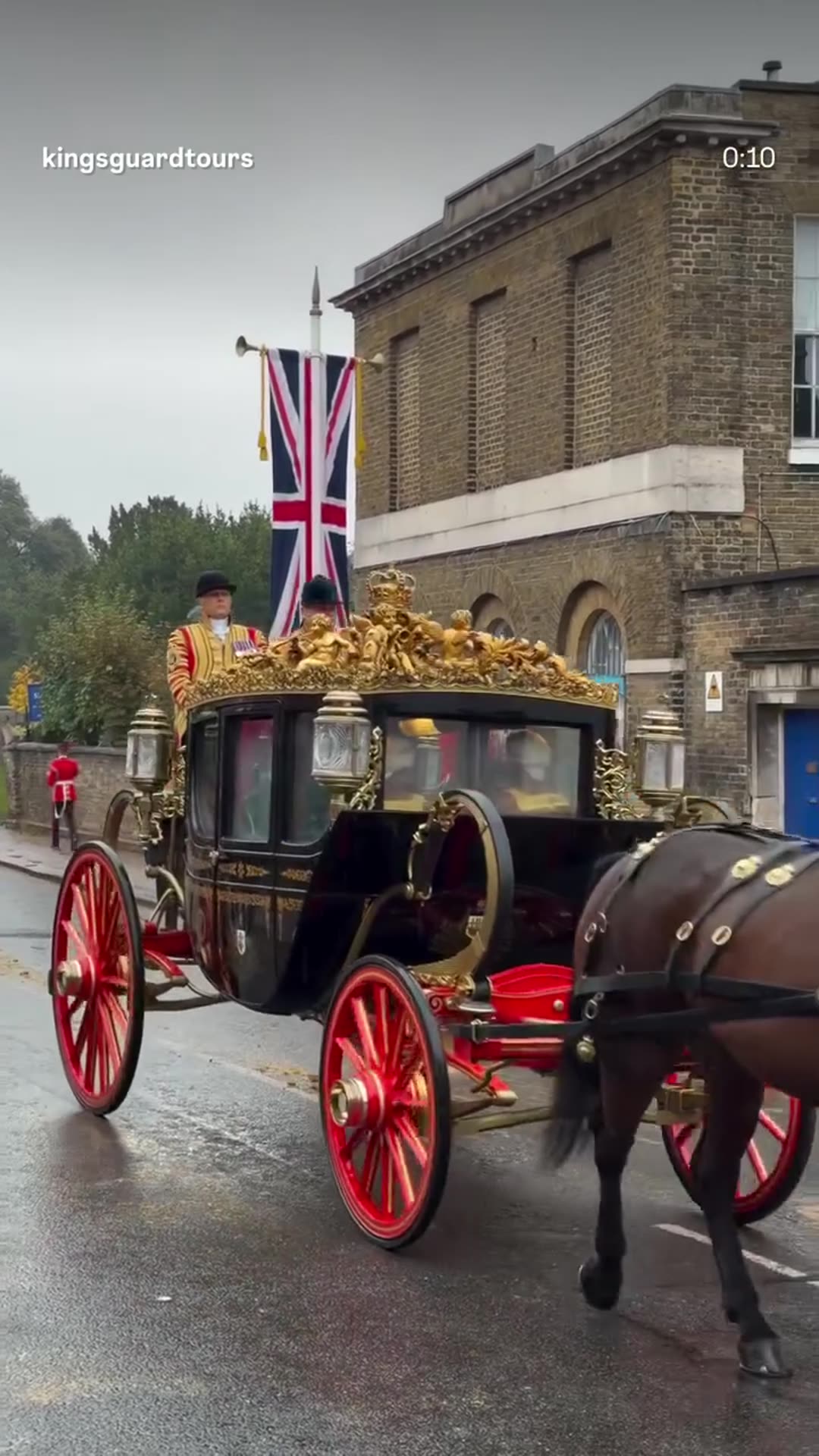 A story reshares King's Guard Tours' reel of the royal carriage procession in the rain to Windsor Castle during the Oman State Visit. A horse-drawn gilded state carriage passes with a Union flag banner. The Omani flag is visible at the end.