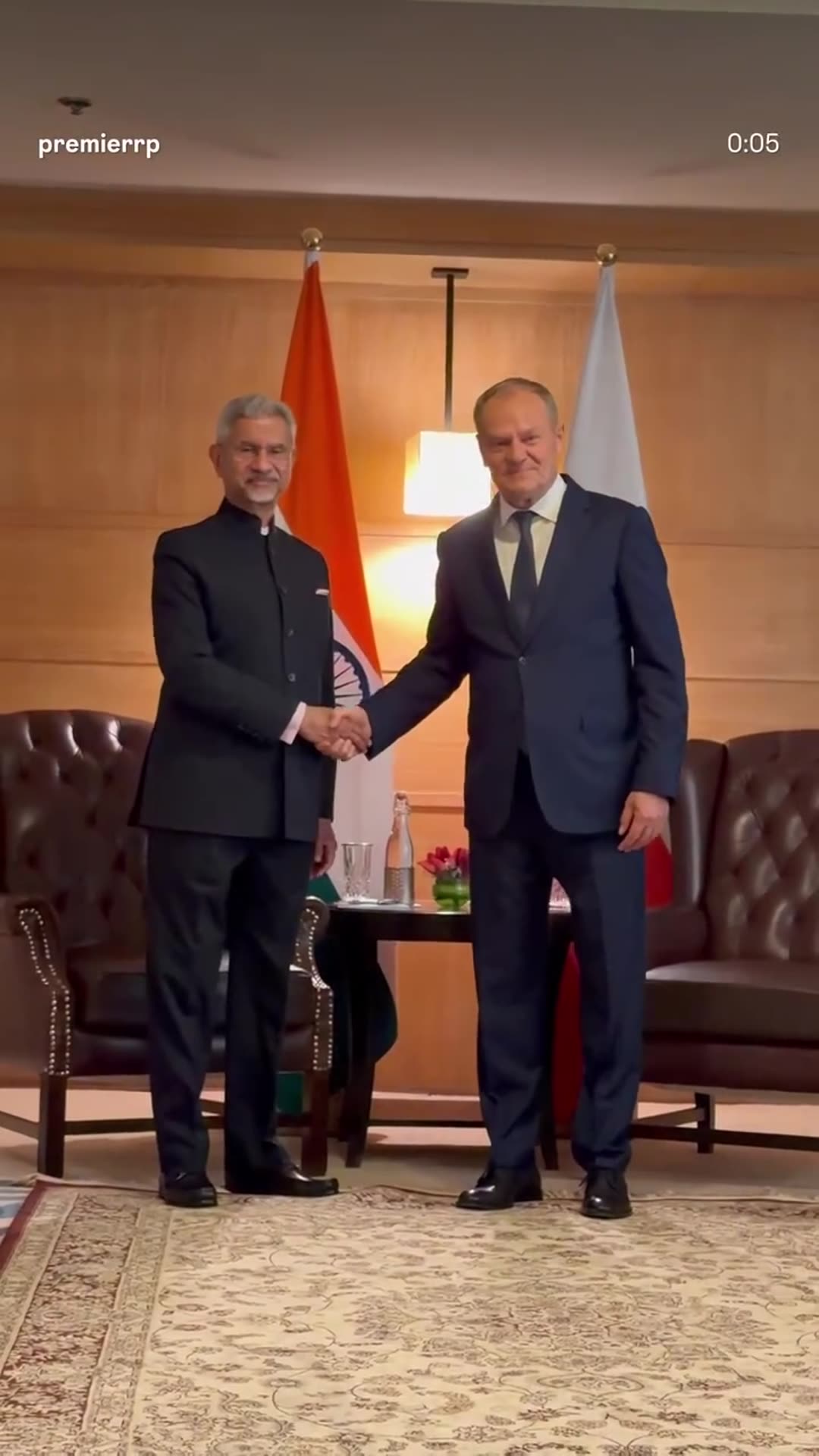 A story reshares the Polish Prime Minister's Chancellery reel of Premier Donald Tusk meeting India's Minister of External Affairs in New Delhi. The clip shows the two men greeting and shaking hands in front of the Indian and Polish flags, then sitting for talks with aides around them.