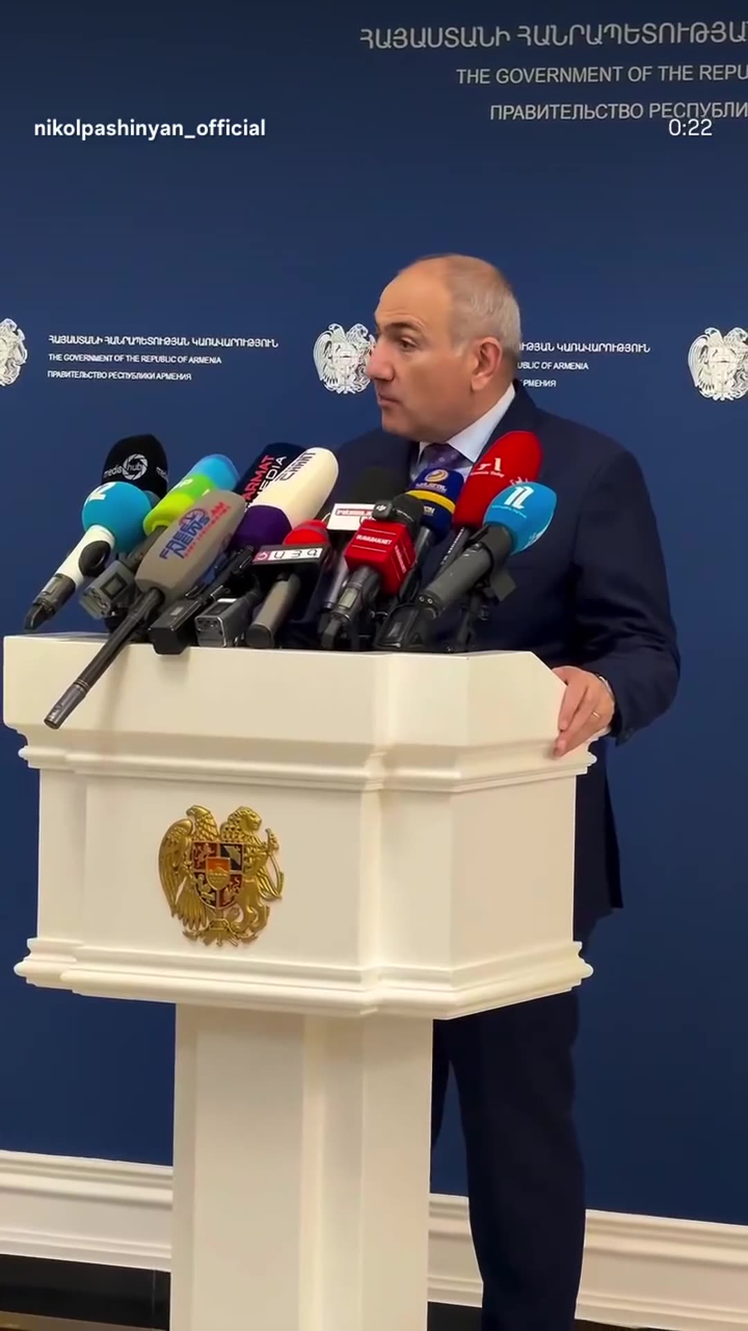 A story reshares a reel from @nikolpashinyan_official showing him answering journalists' questions at a press event in a government building, with reporters asking questions in turn and camera crews filming.