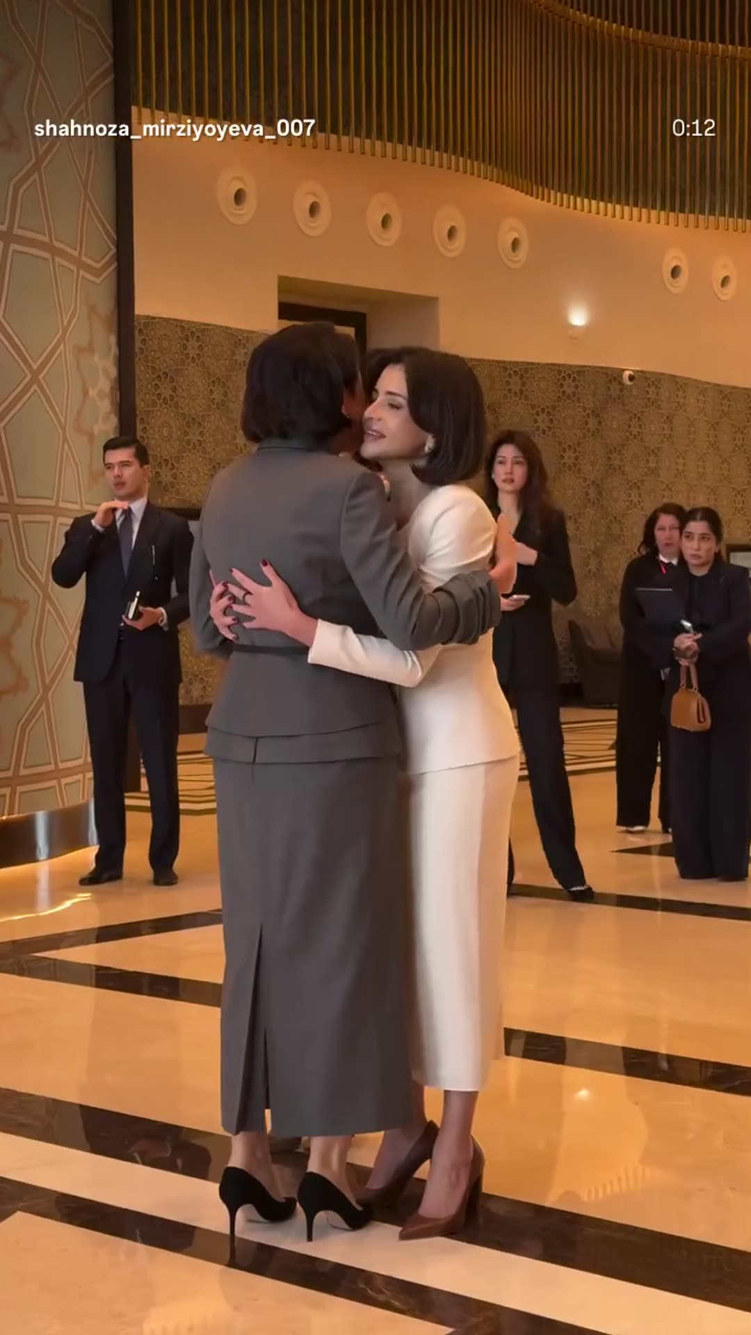 A story reshares a reel of women officials greeting each other with hugs and handshakes in a hall with flags of the 2nd International Congress on Pediatric Oncology and Hematology.
