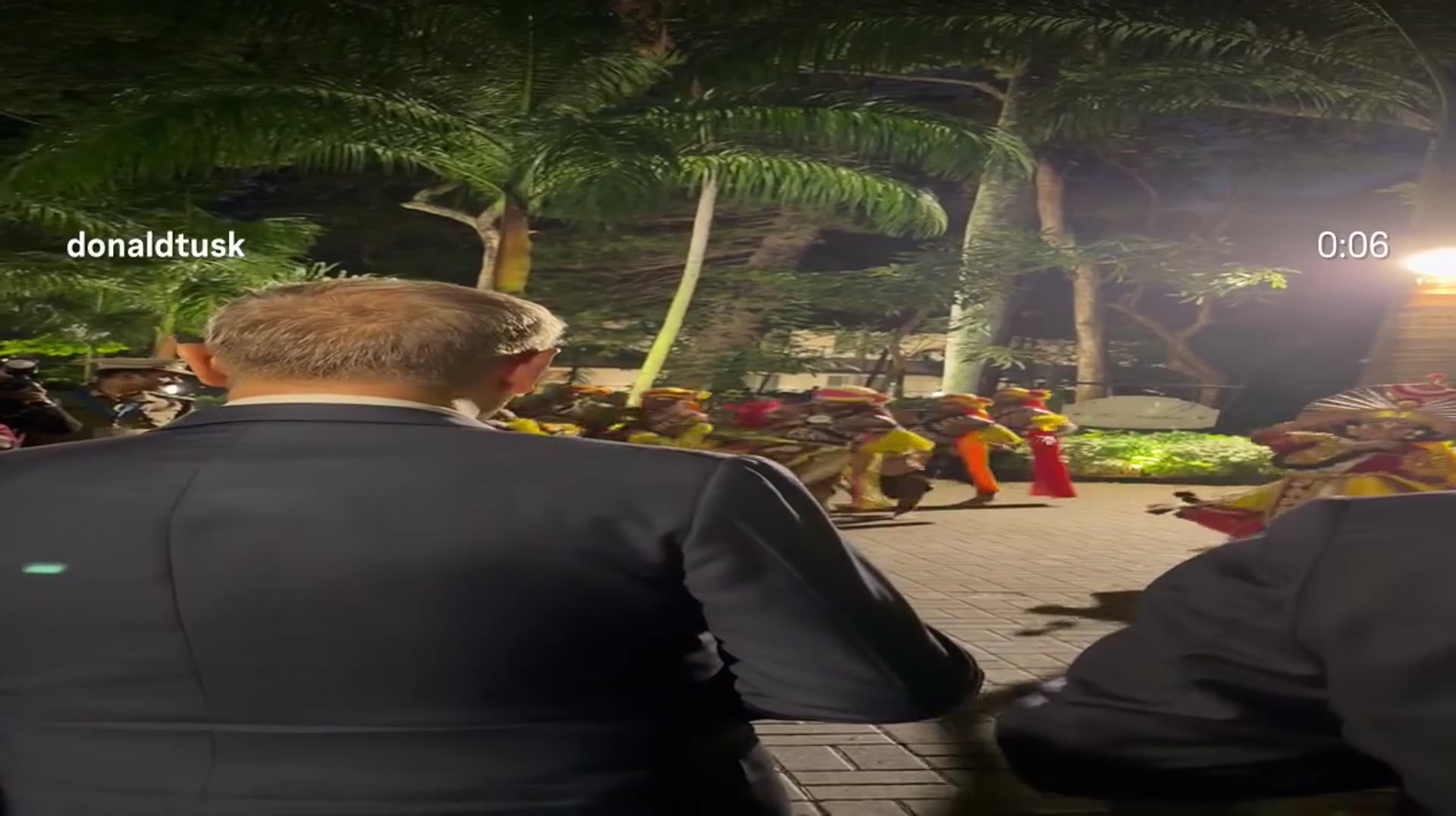 A story reshares a reel by @donaldtusk showing a night-time traditional dance performance in Bengaluru, watched from behind by a man in a dark suit.