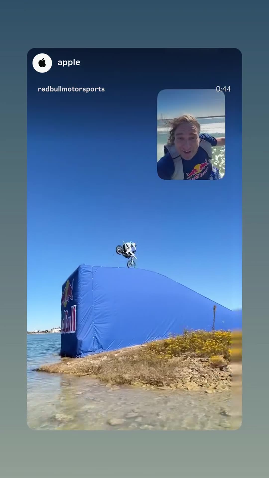 A story reshares a Red Bull Motorsports video, shown via an Apple mention sticker, in which a motocross rider jumps from ramp to ramp across a lake while a man films from a boat and reacts excitedly. It ends with the rider celebrating on top of a ramp.