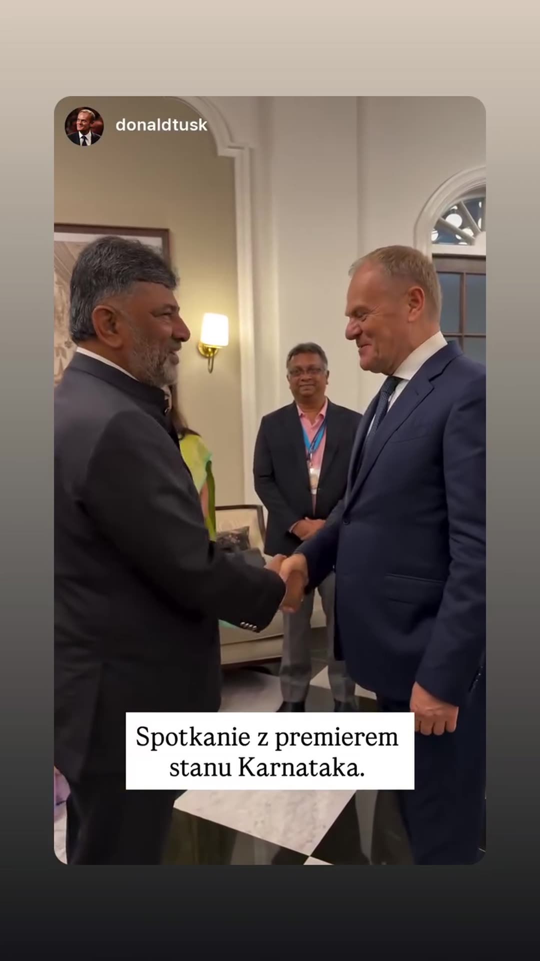 A story reshares a video from Donald Tusk's account showing him greeting and shaking hands with the premier of the Indian state of Karnataka in an elegant room.