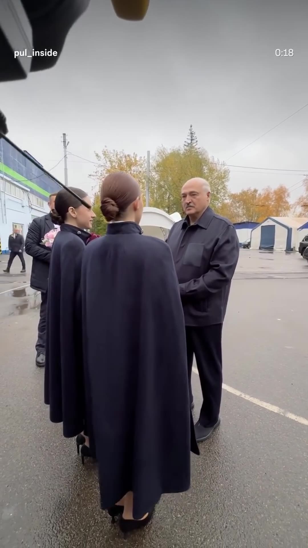 A story reshares a @pul_inside reel showing the ceremonial welcome of Belarusian president Lukashenko, as named in the original caption, at the Belkommunmash site. Two women in capes with a bouquet greet him, followed by a walk-through with officials and a film crew.