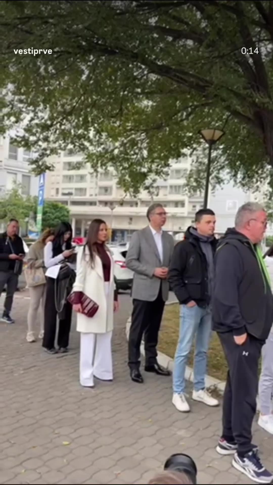 A story reshares a Vesti Prve reel showing Aleksandar Vučić waiting in a queue with citizens at a polling station on Serbian election day, surrounded by press photographers.