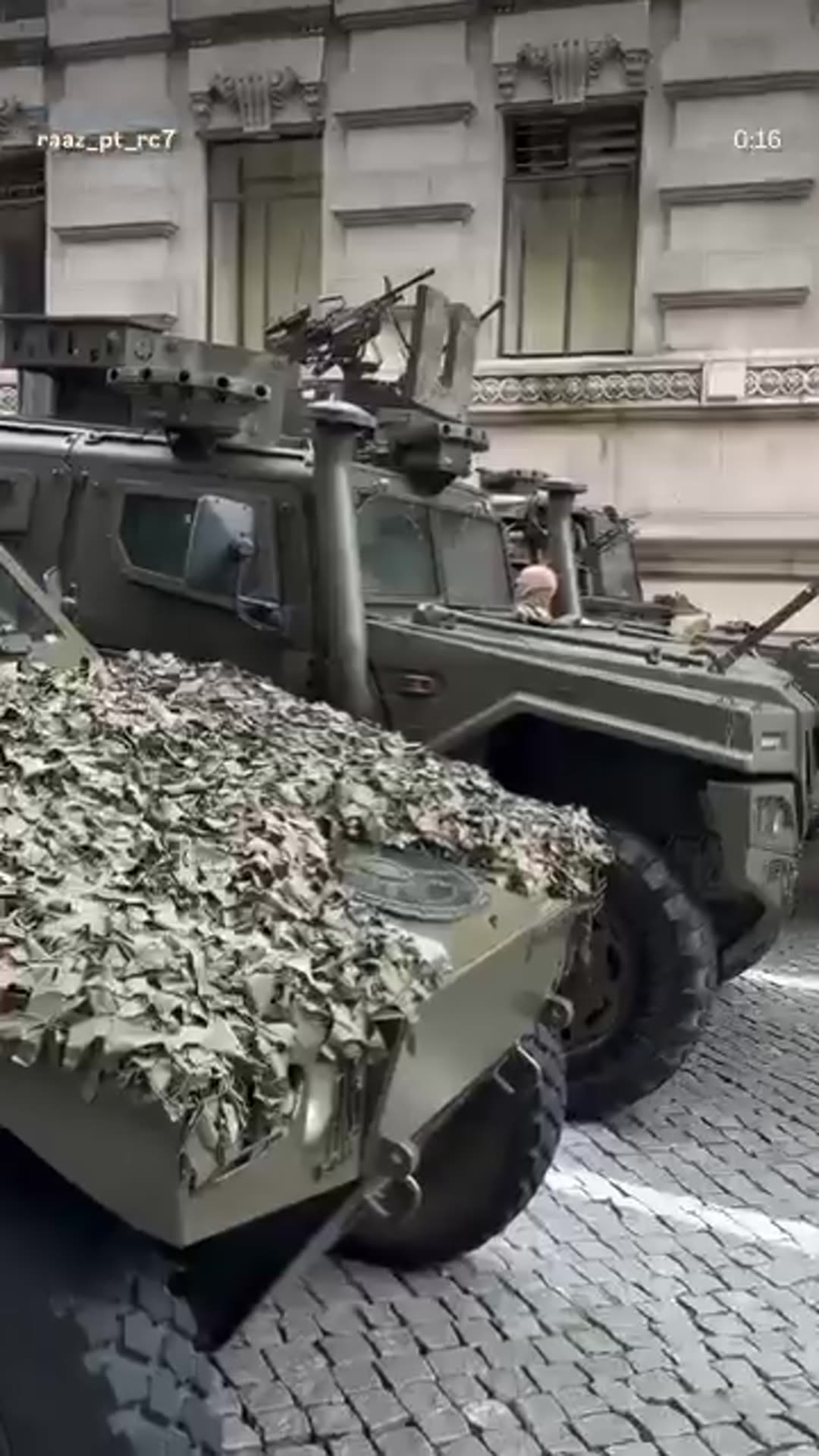 A story reshares a reel by @raaz_pt_rc7 showing soldiers and camouflaged armored military vehicles parked on a city street in Porto, Portugal. The filmer walks past, says it is amazing, and says it is the first time they have seen anything like it.