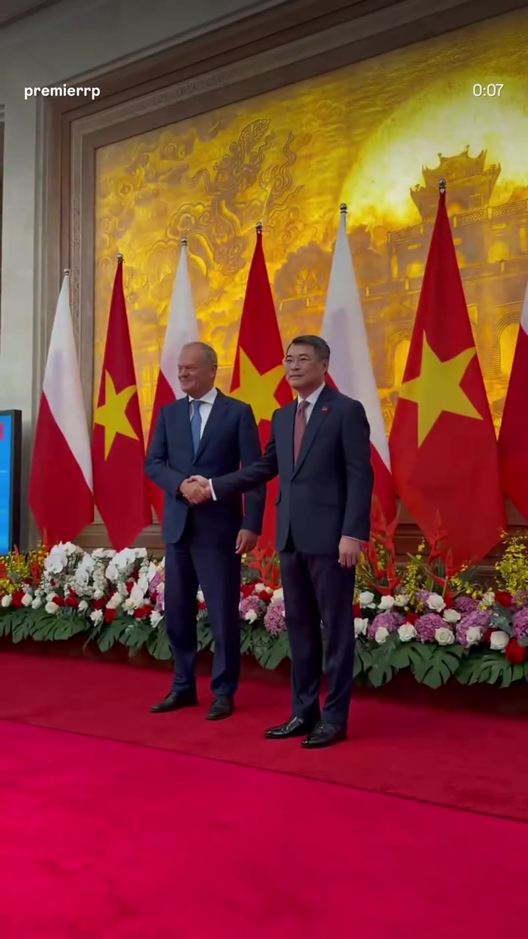 A story reshares the Polish Prime Minister's Office reel from Hanoi: Donald Tusk shakes hands with Vietnam's Prime Minister before national flags, then the two delegations meet at a long table.