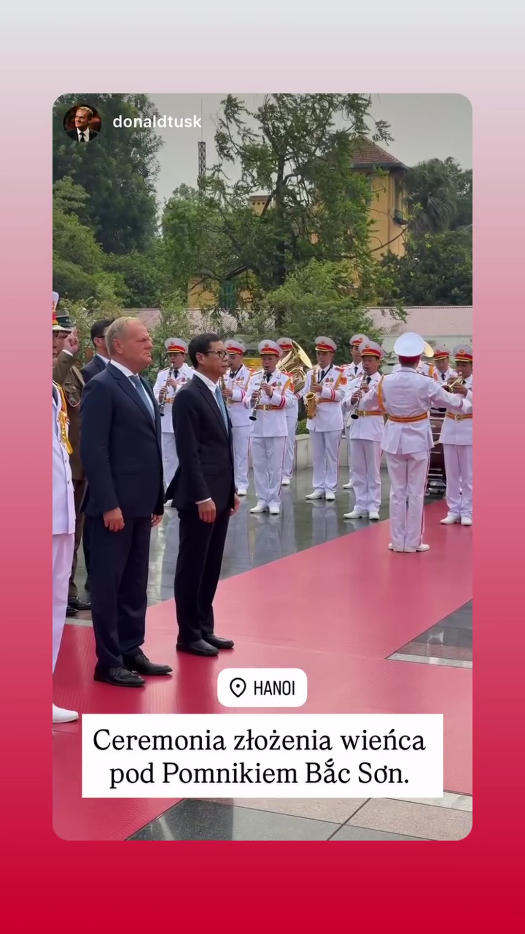 A story reshares a video from Donald Tusk's account of a wreath-laying ceremony at the Bắc Sơn Monument in Hanoi, with white-uniformed honor guards carrying a wreath along a red carpet and a military band playing.