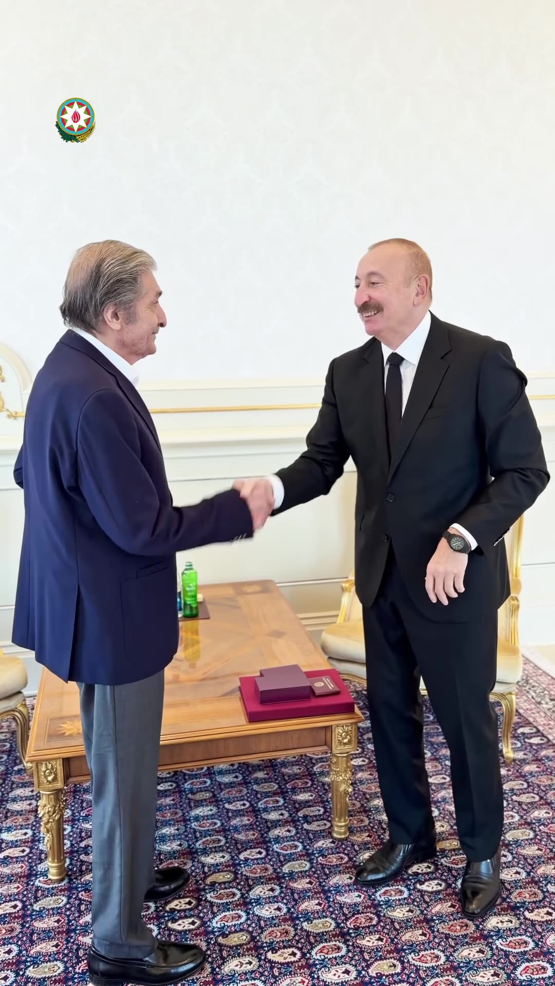 A reshared reel from the Azerbaijani President's account shows President Ilham Aliyev presenting the Order of Independence (Istiqlal) to People's Painter Farhad Khalilov, pinning the medal on his jacket, shaking hands, chatting and posing for a photo.