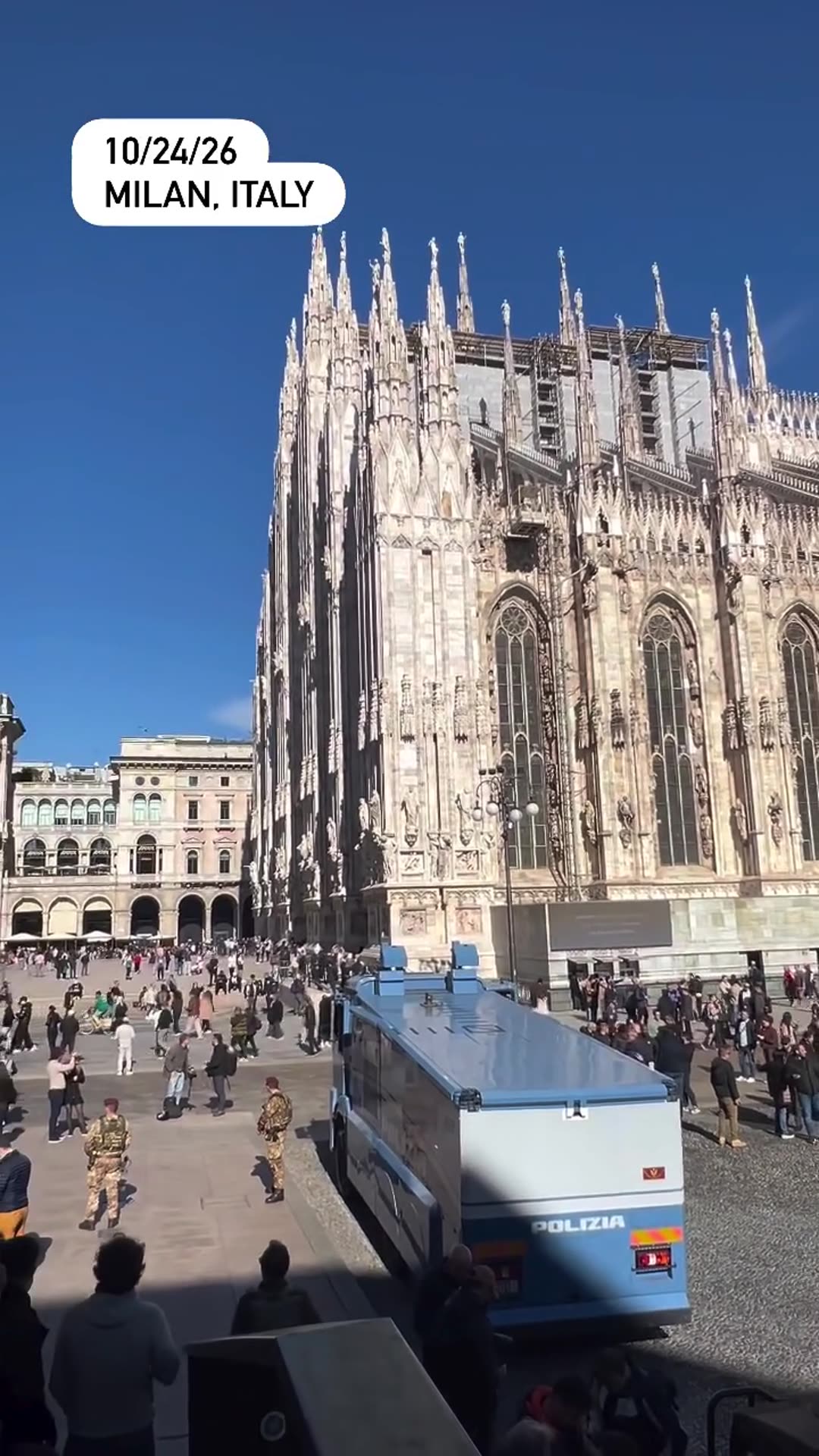 A repost of a reel showing Italian soldiers in maroon berets and camouflaged armored vehicles gathered on the square in front of Milan Cathedral, with a blue Polizia vehicle and crowds nearby.