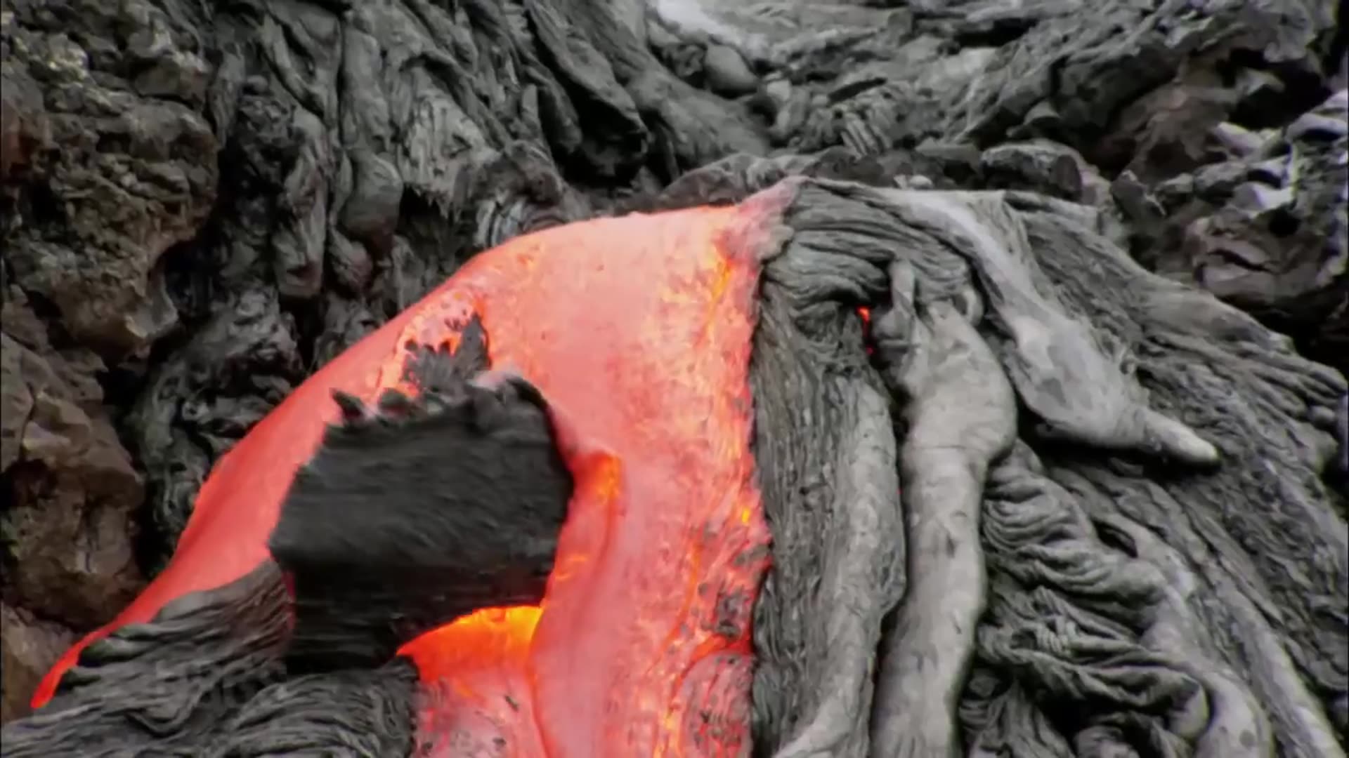 A reel of USGS (U.S. Geological Survey) lava footage: aerial views of a lava flow, a close-up of molten lava, and field workers in respirators sampling lava. It appears to be official USGS video, not the owner's own footage, posted with a Hawaii trip caption.